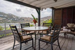 a table and chairs on a deck with a view at Les Balcons d'Oyster Pond in Saint Martin