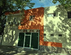 an orange and white building with a door at Hospedaje Los 7 Arcangeles in Termas de Río Hondo