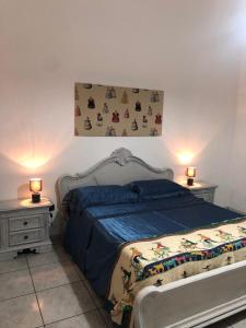 1 dormitorio con 1 cama con 2 mesitas de noche y 2 lámparas en Origini - Apartment with private Garden en Lecce