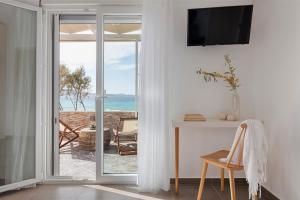 a room with a sliding glass door with a view of the ocean at Mytakas Houses in Mytakas