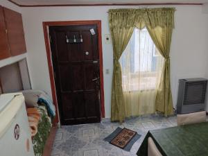 Cette petite chambre dispose d'une porte et d'une fenêtre. dans l'établissement Lupinos 2, à Ushuaia