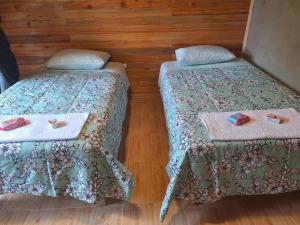 a room with two beds with towels on them at Oxaturismo Perú in Oxapampa