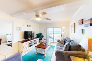 a living room with a couch and a tv at Regency Towers W 707 in Pensacola Beach