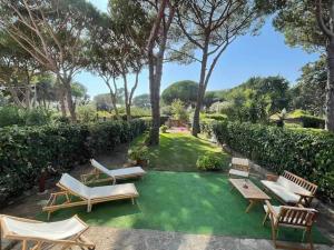 a backyard with chairs and a green lawn at L'Antico casale dell'800 in Albinia
