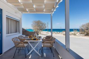 a table and chairs on a patio with a view of the ocean at Mytakas Houses in Mytakas