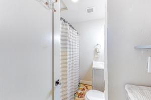 baño con aseo y puerta de ducha de cristal en Make Mine Mesa - Unit B, en Mesa