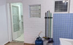 baño con paredes de azulejos azules y ventana en Charmoso e confortável com A/C, en Pindamonhangaba