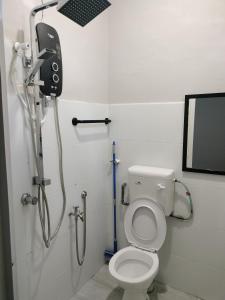 a bathroom with a shower with a toilet and a phone at RINA HOMESTAY Kemaman in Cukai