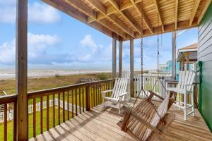 a porch with rocking chairs and a view of the beach at Sunrise in Paradise in Galveston