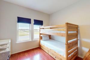 a bedroom with two bunk beds and a window at Sunrise in Paradise in Galveston