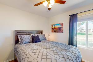 um quarto com uma cama, uma ventoinha de tecto e uma janela em Valley of the Sun em Phoenix