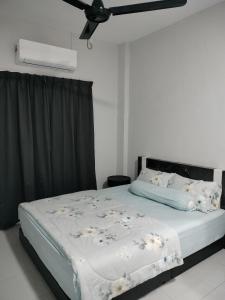 RINA HOMESTAY Kemaman في Cukai: سرير في غرفة نوم مع مروحة سقف