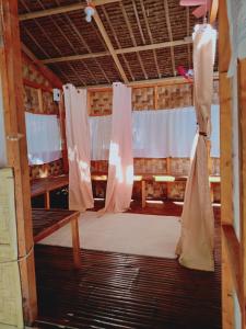 een kamer met een bed en gordijnen in een gebouw bij Wellness & Fitness In Life Rejuvenating Kubo La Union 