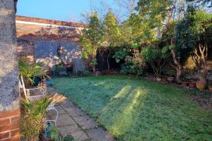 a backyard with a lawn with a chair and trees at Majestic! Beautiful home in a posh neighbourhood in Liverpool