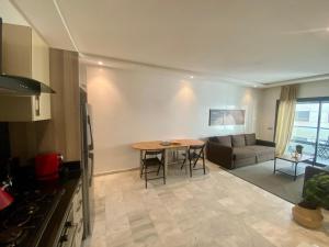 a kitchen and living room with a table and a couch at Appartement les pieds dans l'eau in Mohammedia