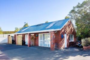 una casa de ladrillo rojo con techo solar en Superior Dunedin Apartments, en Dunedin