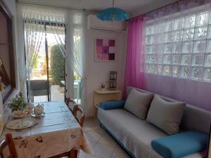a living room with a couch and a table at Apartment in green and quite area, close to beach in Šilo