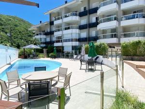 a patio with a table and chairs next to a building at Residencial Porto da Brava - NDI001 in Florianópolis