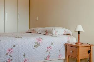 Un dormitorio con una cama y una lámpara en una mesita de noche. en Residencial Porto da Brava - NDI001, en Florianópolis 33 fotos más