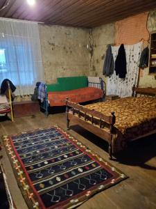 a bedroom with two beds and a rug on the floor at paradise of tusheti in Omalo