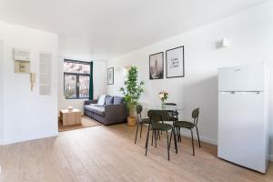 sala de estar con mesa, sillas y sofá en Lille - Bel Appartement Cosy et Lumineux en Lille