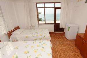 um quarto com duas camas e uma janela com o oceano em PINAR OTEL em Amasra
