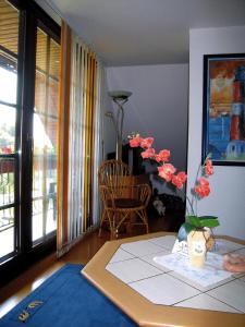 Una habitación con una mesa con un jarrón con flores. en Exklusive Ferienwohnung in Wilhelmsfehn mit Garten, Grill und Terrasse, en Wiesmoor