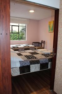 two beds in a room with a mirror at Casa de Tulia in Quito