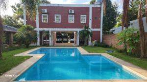 a swimming pool in front of a house at Cabañas La Dorita in Paso de la Patria