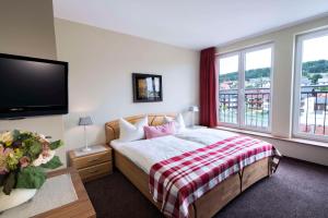 een slaapkamer met een bed en een flatscreen-tv bij Best Western Hotel Brunnenhof in Weibersbrunn