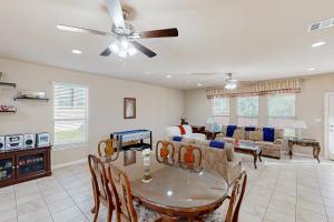 a living room with a ceiling fan and a table at Hidden Springs Oasis in San Antonio