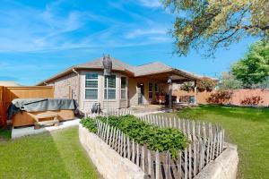 a house with a wooden fence in the yard at Hidden Springs Oasis in San Antonio