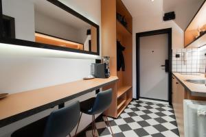 La salle de bains est pourvue d'un lavabo et d'un comptoir avec des chaises. dans l'établissement Dimov Center Apartment, à Skopje