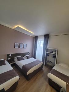 ein Hotelzimmer mit 2 Betten und einem Fenster in der Unterkunft HOTEL KYRIAD ORANGE Centre Ville - A7-A9 - 3 Etoiles - HOTEL DES PRINCES - Provence Alpes Côte d'Azur - France in Orange