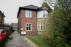 a brick house with white windows and a yard at Thornton House Apartments, Cambridge - FREE On-site Parking in Girton