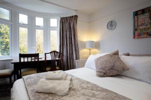 a bedroom with a bed and a desk and window at Thornton House Apartments, Cambridge - FREE On-site Parking in Girton