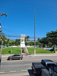 ein Auto, das eine Straße entlangfährt, auf der Autos geparkt sind in der Unterkunft Duplex Beira Mar Pajuçara Maceió in Maceió