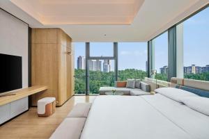 - une chambre avec un grand lit blanc et une grande fenêtre dans l'établissement DoubleTree by Hilton Guangzhou Zengcheng, à Canton