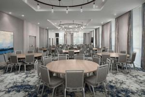 een vergaderzaal met tafels en stoelen en een kroonluchter bij Hilton Garden Inn Pensacola Downtown in Pensacola