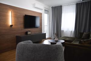 a living room with a couch and a tv at CROWN apartment 3 in Subotica