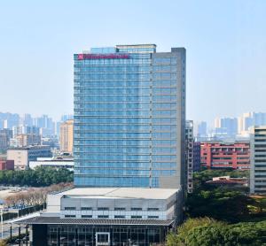 un grand bâtiment avec beaucoup de fenêtres dans une ville dans l'établissement Hilton Garden Inn Wuhan Hankou, à Wuhan