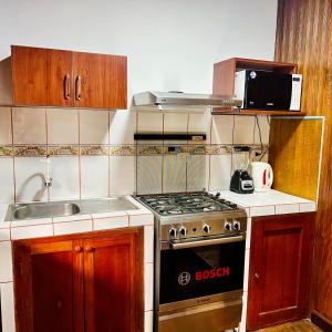 a small kitchen with a stove and a sink at CHALET TARAPOTO in Tarapoto