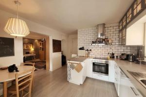 a kitchen with white cabinets and a table and a dining room at Superb and central place! Airb&b favorite in Bergen