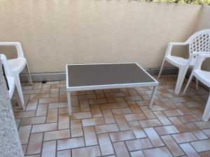a coffee table and chairs on a patio at Deux chambres dans villa proche de la plage in Sète