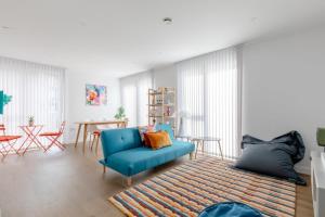 a living room with a blue chair and a table at Stylish 2BD Oasis wBalcony South East London! in London