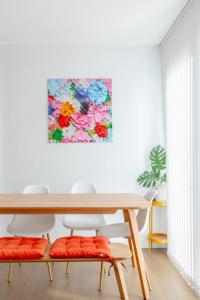 a dining room table with orange cushions and a painting at Stylish 2BD Oasis wBalcony South East London! in London