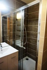 a bathroom with a glass shower with a sink at Résidence Rond Point I - Studio pour 4 Personnes 04 in Orcières