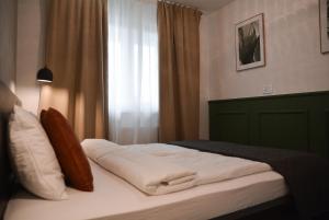 a bed in a hotel room with a window at CROWN apartment 3 in Subotica
