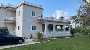 a house with a car parked in front of it at 4-BRS Entire FarmHouse in Ismailia lGreen Paradise in Ismailia