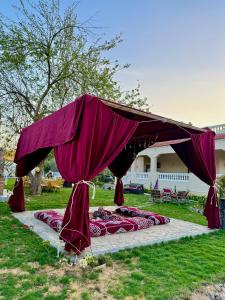 a purple canopy over a group of beds on the grass at 4-BRS Entire FarmHouse in Ismailia lGreen Paradise in Ismailia